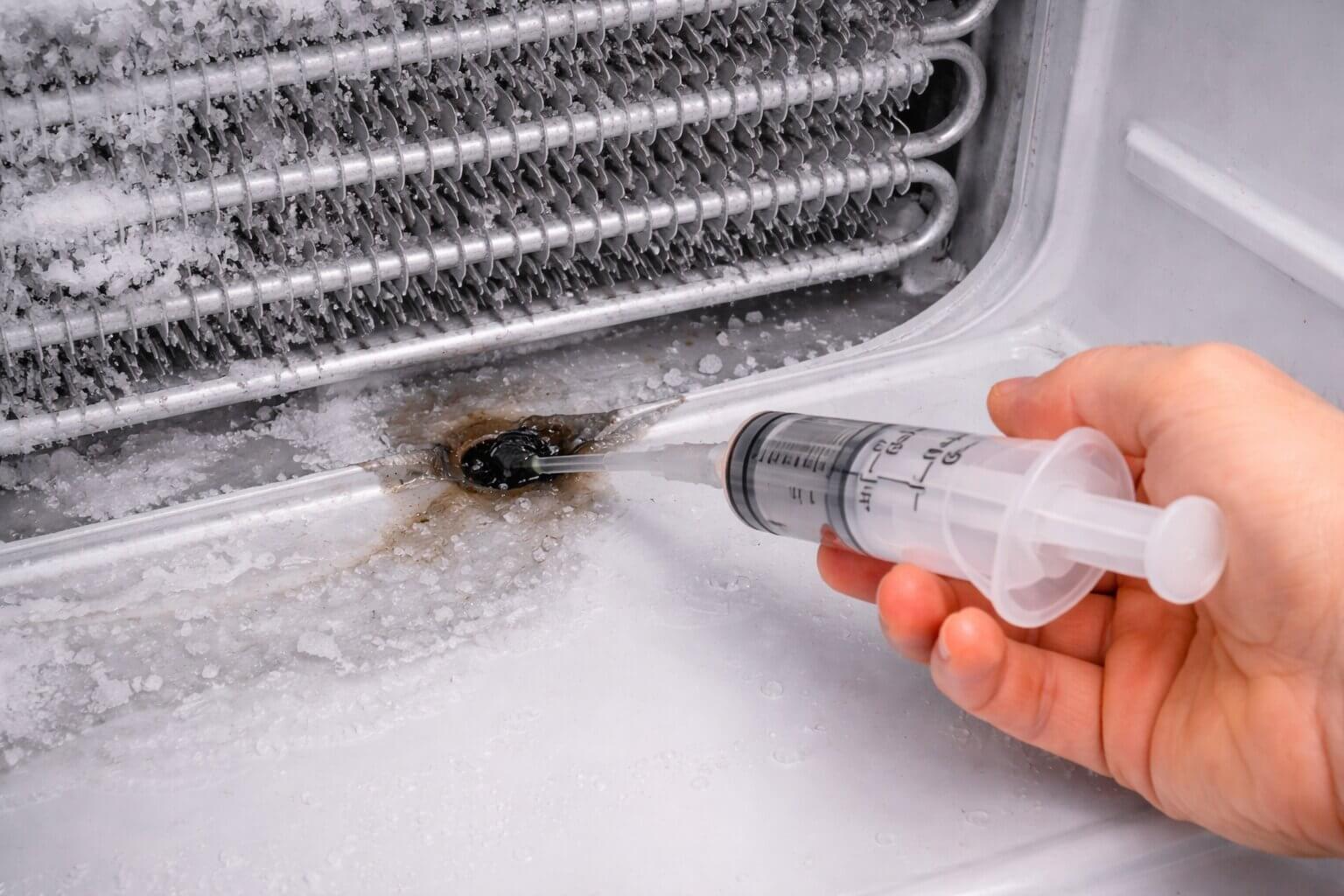 Using a hot water syringe to unclog a frozen refrigerator defrost drain tube
