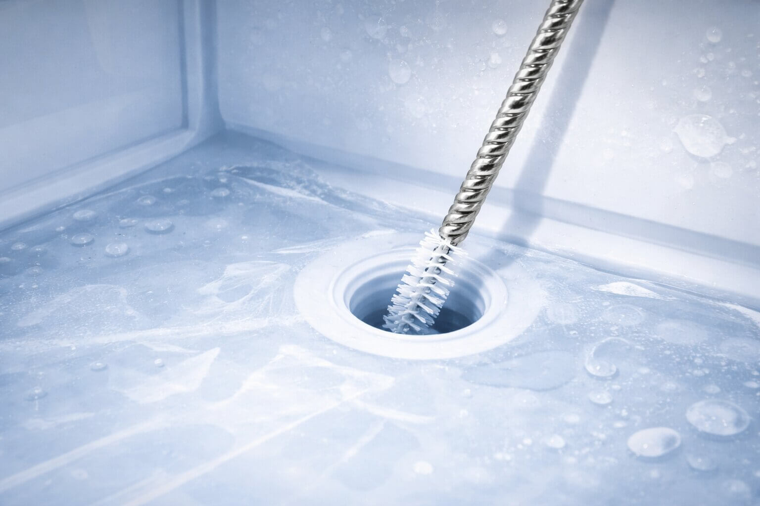 Unclogging a frozen refrigerator water line tube with a flexible syringe tool